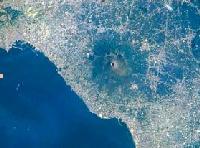 Esempio di urbanizzazione, (colore chiaro) intorno al cono vulcanico del Vesuvio (al centro). Napoli è in alto a sinistra (immagine ripresa dallo Shuttle nel 1996, fonte NASA